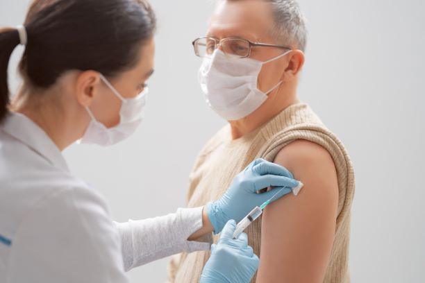 Person with mask getting a vaccine shot