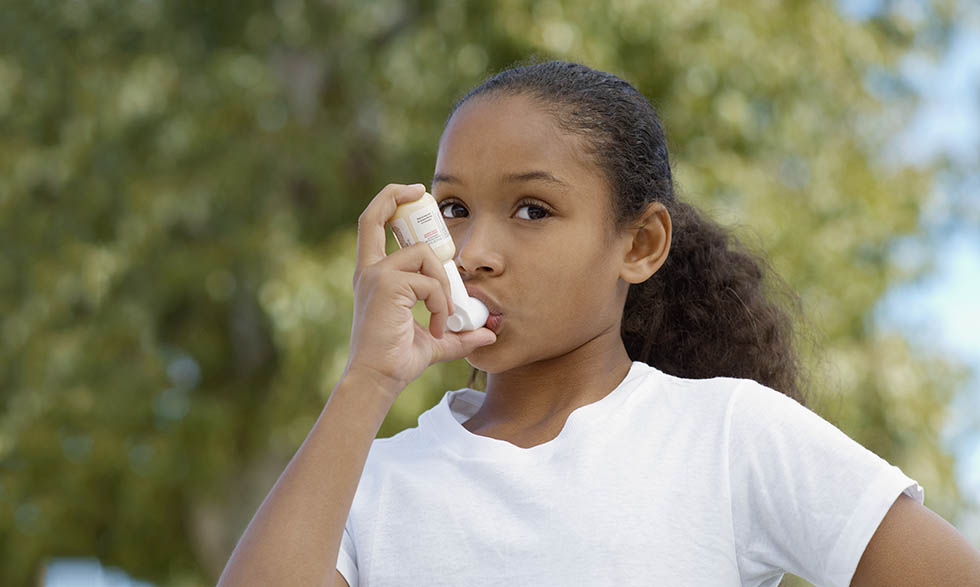 Young girl using inhaler.