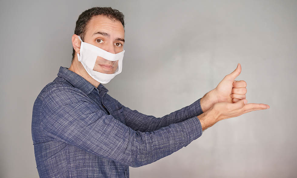 Man wearing a face mask with a clear window for lip-reading