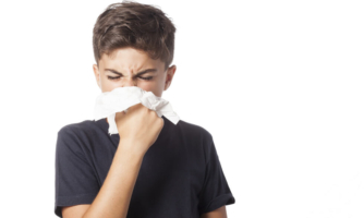 Boy covering sneeze with tissue