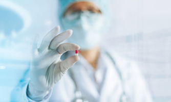 Doctor holding a white and red pill
