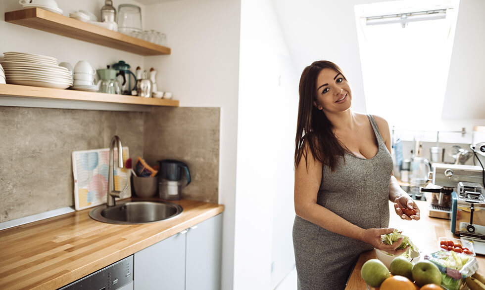 Plus-size pregnant woman in kitchen
