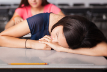 Girl sleeping at school desk