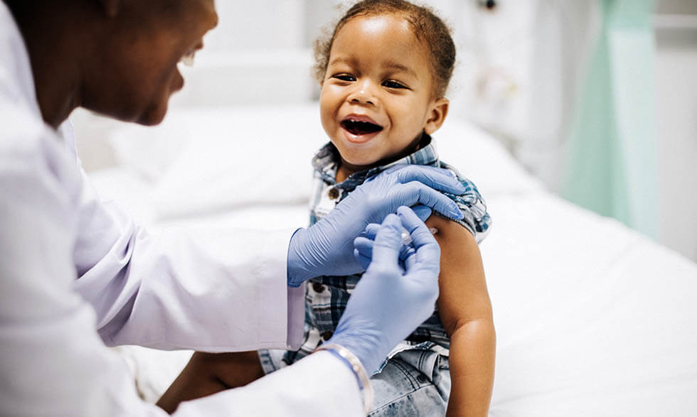 Child smiling while getting a vaccine shot