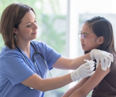 Nurse giving young girl an arm shot