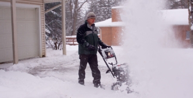 Man using a snowblower in driveway