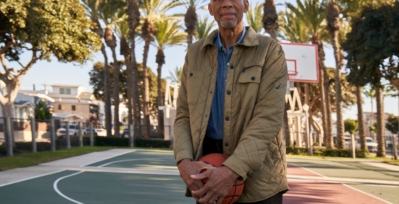 Kareem Abdul-Jabbar standing on an outdoor basketball court.